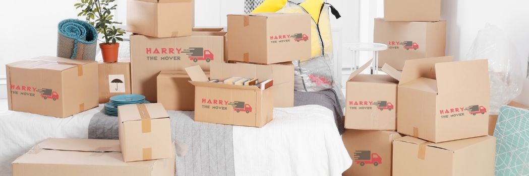 10 Questions That Every Client Should Ask Removalist Company 4 Moving boxes branded with 'Harry The Mover' stacked in a room, ready for relocation in Melbourne.